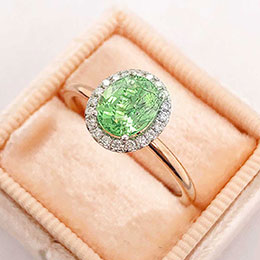 ring with diamonds and green gemstone