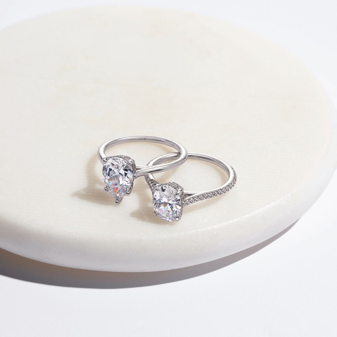 how often to clean an engagement ring images with two hidden halo engagement rings sitting on a white marble coaster