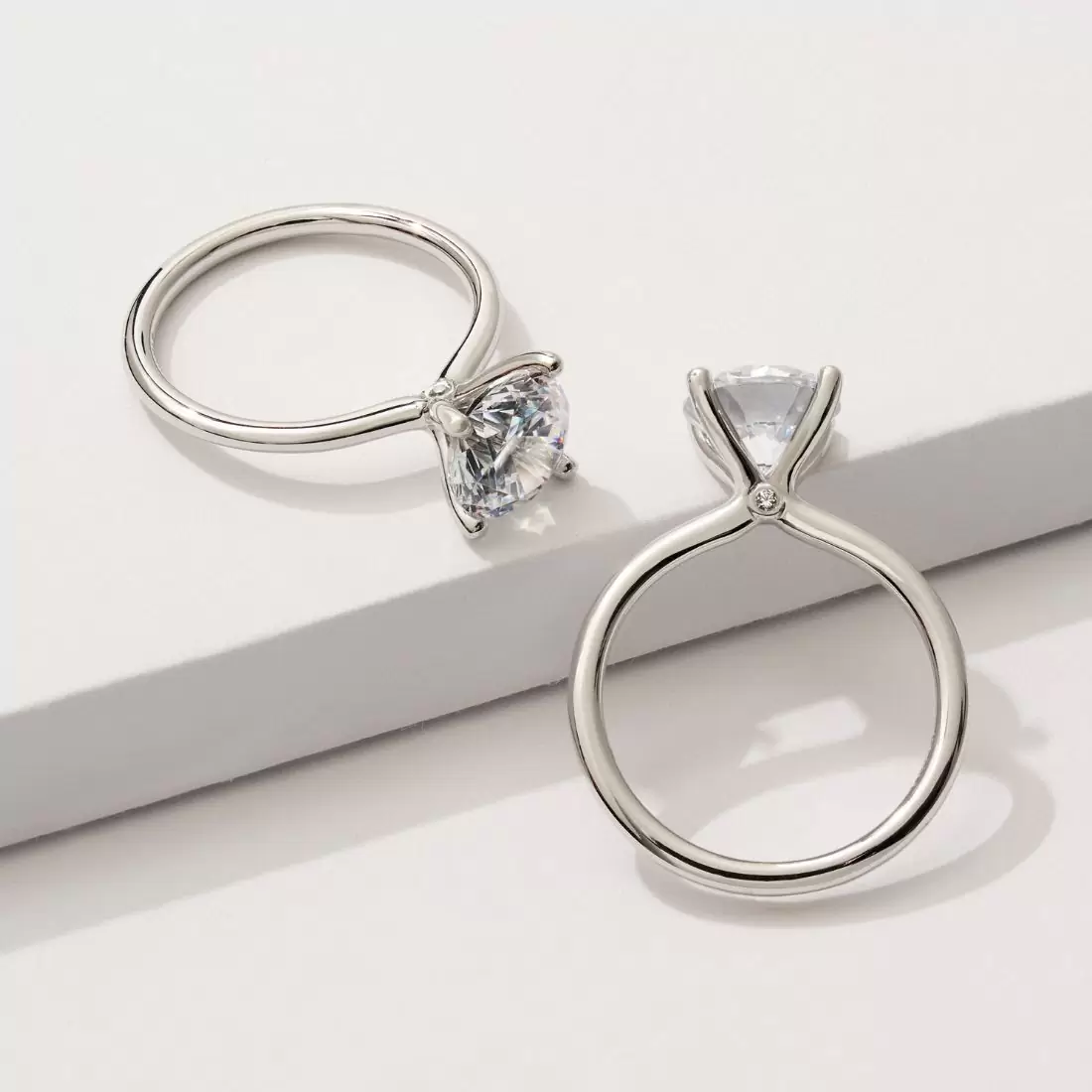 round cut solitaire engagement ring with a peek-a-boo diamond