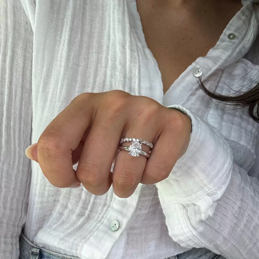 how often to clean an engagement ring blog image that features woman wearing a solitaire engagement ring with a baguette wedding band