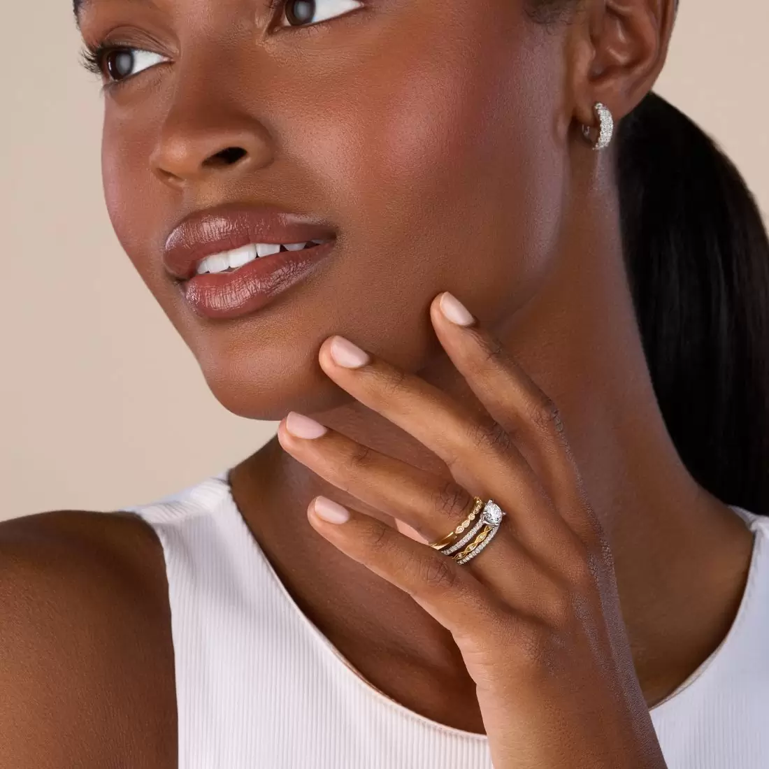 woman wearing a ring stack featuring a solitaire engagement ring